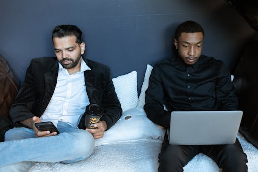 Man in Black Jacket Sitting on Couch Beside Man in Black Jacket